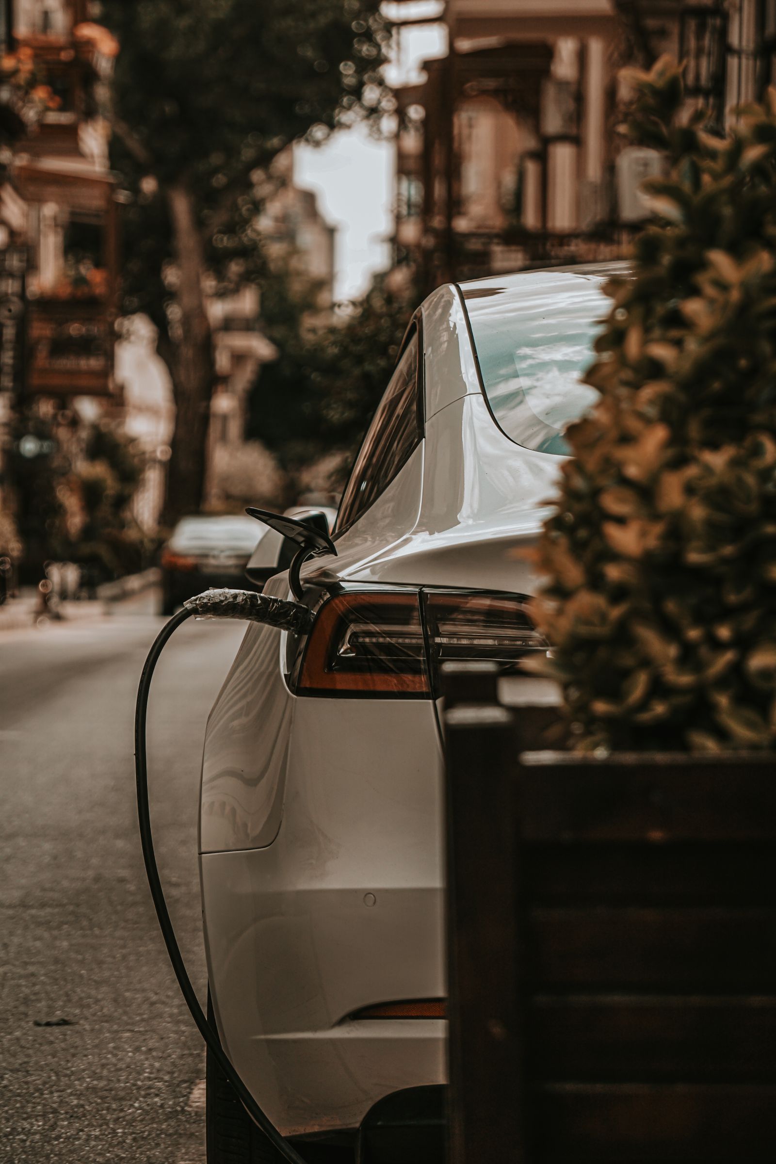 Vehículo eléctrico cargando en una calle urbana